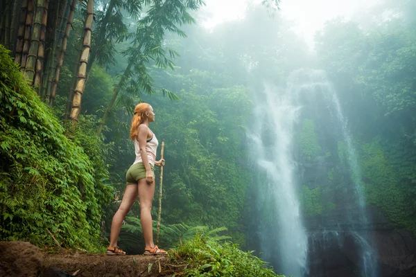 Abenteurerin blickt auf Wasserfall — Stockfoto