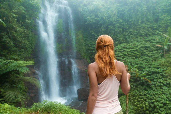 Femme aventurière regardant la cascade — Photo