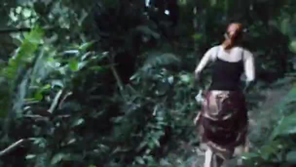 Young woman running thorough jungle — Stockvideo