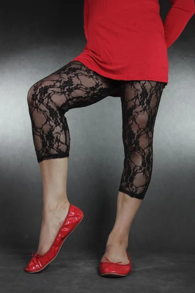 Γυναίκα τα πόδια φορώντας μαύρη δαντέλα κολάν και το κόκκινο φόρεμα — Φωτογραφία Αρχείου