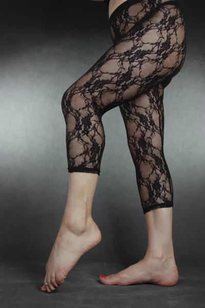 Siyah giyen kadın bacaklar tozluk gri arka plan üzerinde dantel. — Stok fotoğraf