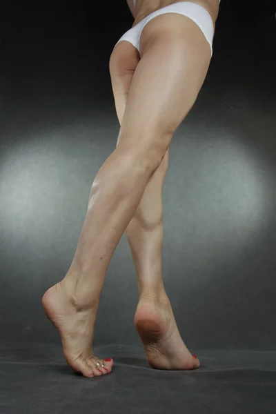 Jambes et pieds de femme portant des sous-vêtements sur fond gris — Photo