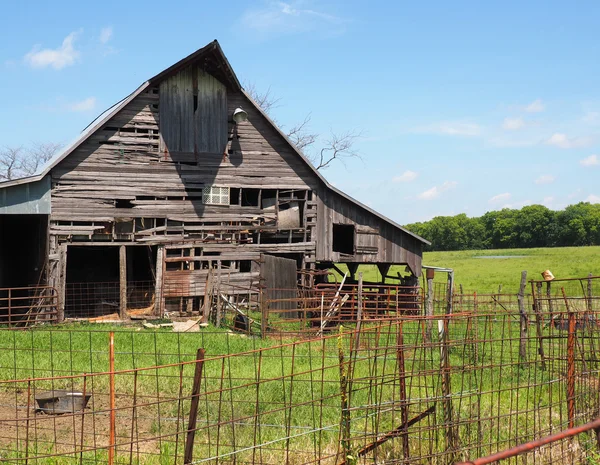 Ancienne grange en bois par une clôture rouillée — Photo