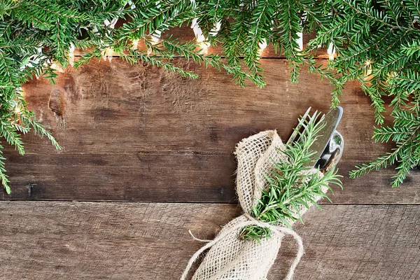 Dennennaalden en verlichting met zilverwerk over houten achtergrond — Stockfoto