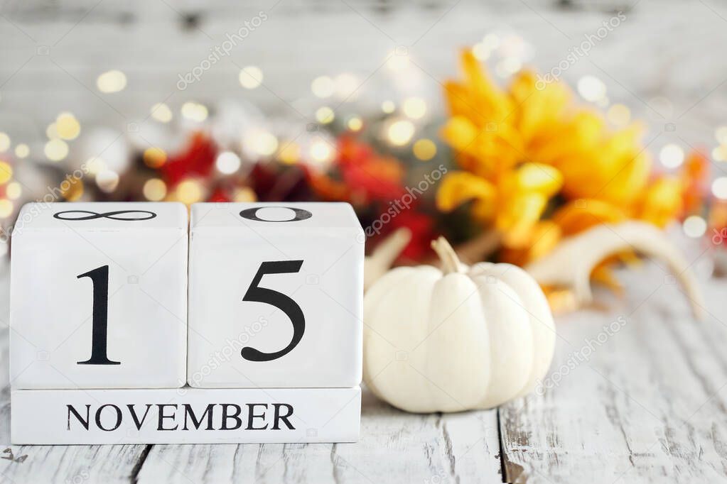 National Recycling Day. White wood calendar blocks with the date November 15th and autumn decorations over a wooden table. Selective focus with blurred background. 
