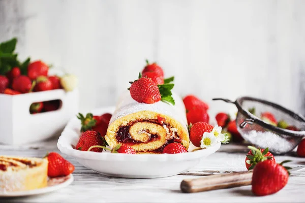自制草莓薄饼卷或带有浆果果酱和薄荷叶糖粉的Roulade 在一个白色的乡村木桌上甜点 具有模糊前景和背景的选择性重点 — 图库照片