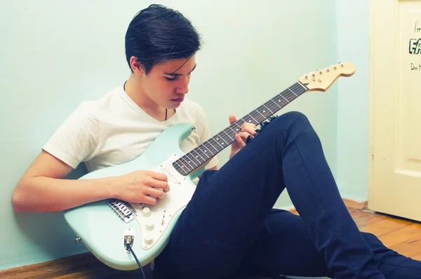 Bonito adolescente tocando guitarra elétrica em casa — Fotografia de Stock