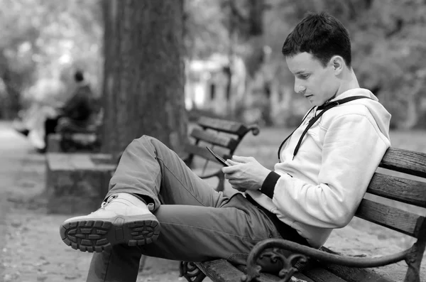 Hombre joven trabajando en la tableta en el parque de primavera —  Fotos de Stock