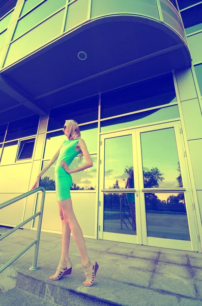 Beautiful tall fashion model posing in front of modern building — Stock Photo, Image