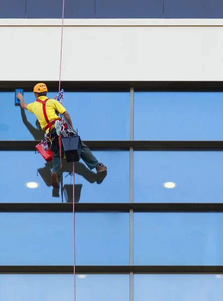 Trabalhador alpinista lavando janelas do edifício moderno — Fotografia de Stock