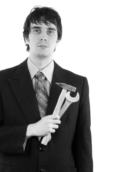 Young businessman holding hammer and wrench — 图库照片