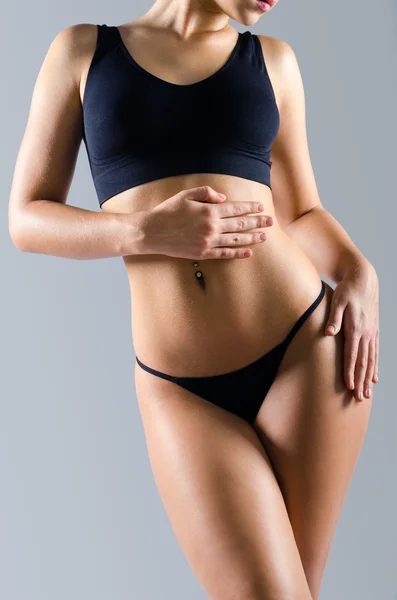 Sexy mięśni dopasowanie kobiecego ciała w czarne majtki i czarny top — Zdjęcie stockowe