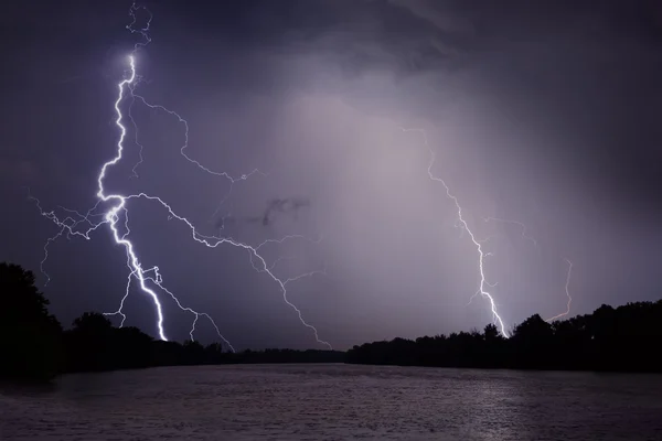 Truenos, relámpagos y lluvia durante la tormenta sobre el río y el bosque —  Fotos de Stock