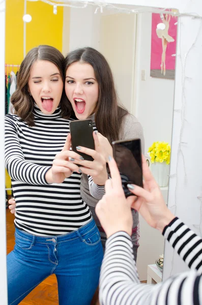 Two beautiful teenage girls taking selfies while making faces — Stock Photo, Image