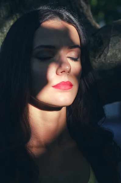 Портрет красивой грустной девушки, прячущейся в тени солнечным летом — стоковое фото