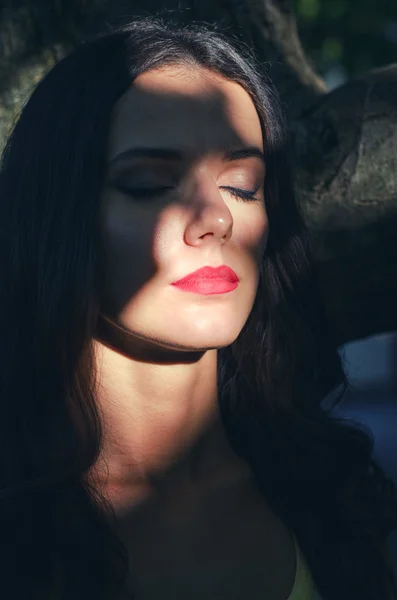 Portrait of beautiful sad girl hiding in shadows on sunny summer Royalty Free Stock Photos