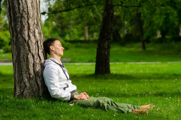 Feliz joven relajándose en el parque en el soleado día de primavera —  Fotos de Stock