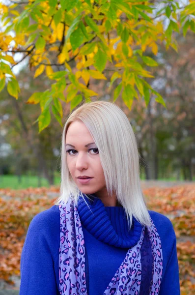 Beautiful blonde girl walking in the park on autumn day — Stock Photo, Image