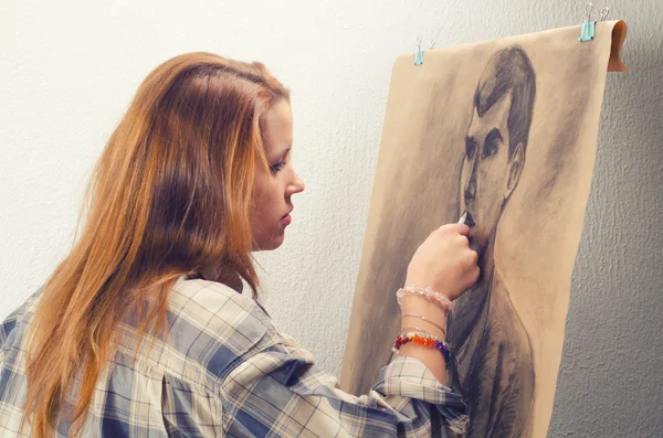 Jovem artista feminina desenho homem retrato em seu estúdio de arte — Fotografia de Stock