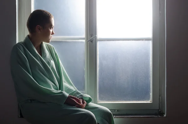 Paciente joven con cáncer sentado frente a la ventana del hospital — Foto de Stock