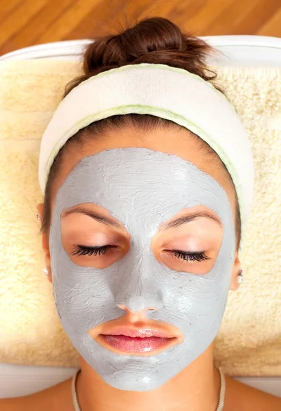 Vacker ung kvinna ligga på massagebänk med naturlig ansiktsbehandling — Stockfoto