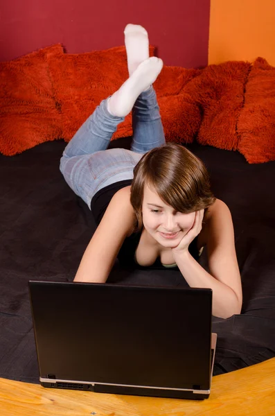 Feliz chica adolescente divirtiéndose con portátil en casa — Foto de Stock
