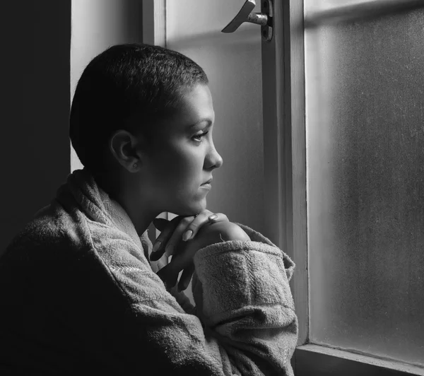 Young cancer patient standing in front of hospital window — Stock Photo, Image