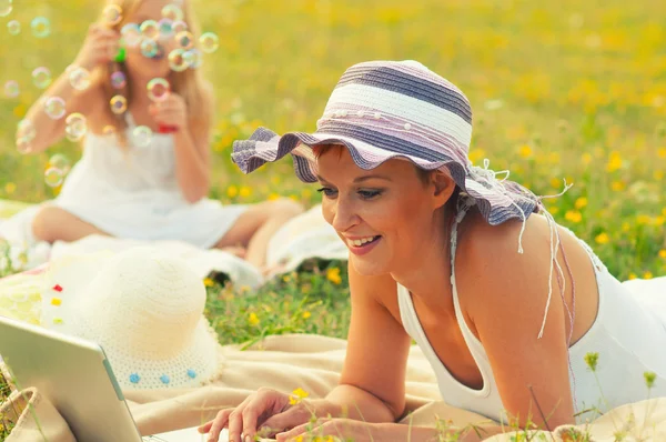 Mother and daughter having fun on the meadow on sunny spring day — Stock Photo, Image