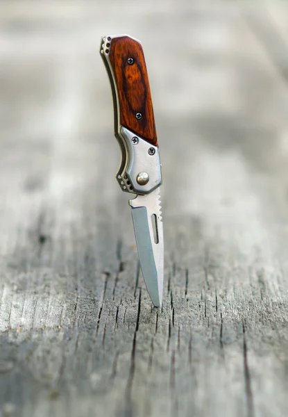 Malé kapesní nůž bodl do dřevěný stůl — Stock fotografie