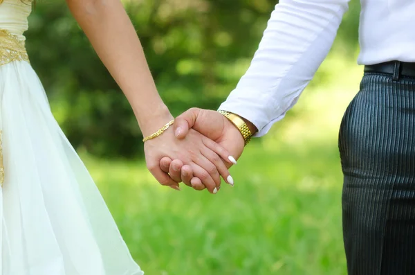 Bride and groom holding hands on wedding ceremony in summer nature — Stock Photo, Image