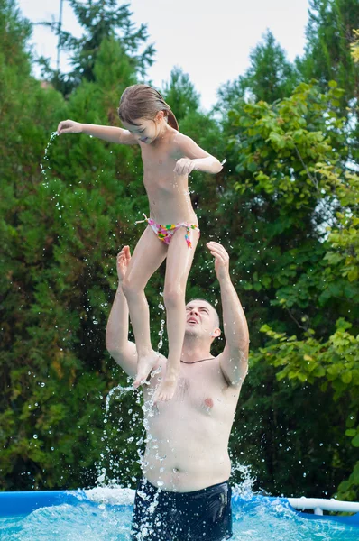 Baba ve kız eğleniyor yüzme havuzunda sıcak yaz gününde — Stok fotoğraf