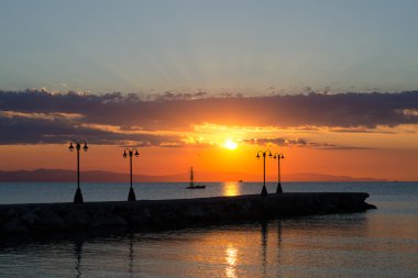 Dock ve candelabras üzerinde gündoğumu denizde yaz siluetleri