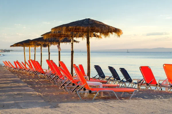Палубные стулья и зонтики на морском пляже летом — стоковое фото