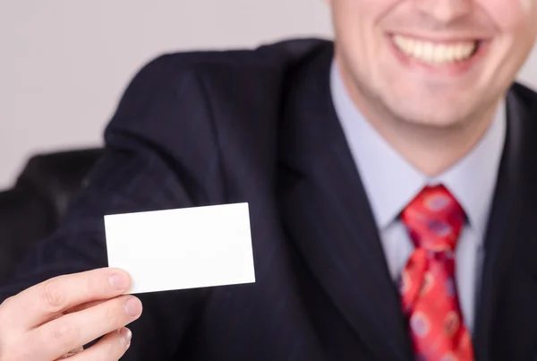 Guapo hombre de negocios sonriente mostrando tarjeta de visita con espacio para su mensaje — Foto de Stock