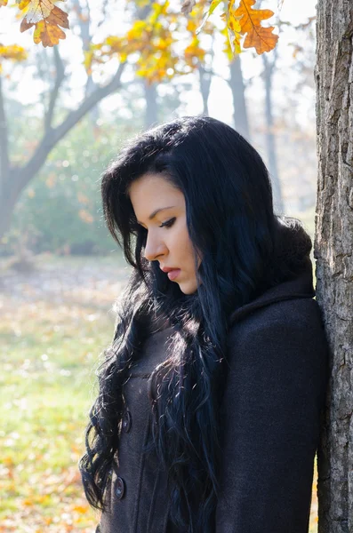 Portrait of the beautiful sad girl in forest on sunny autumn day — Stock Photo, Image