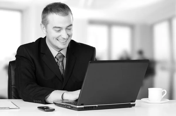 Unga happy business man som arbetar på anteckningsboken i office — Stockfoto