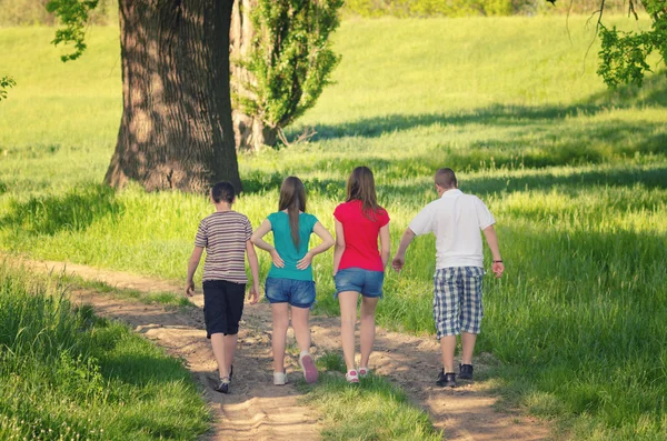 Teenage boys and girls walking in nature on sunny spring day — Stock Photo, Image