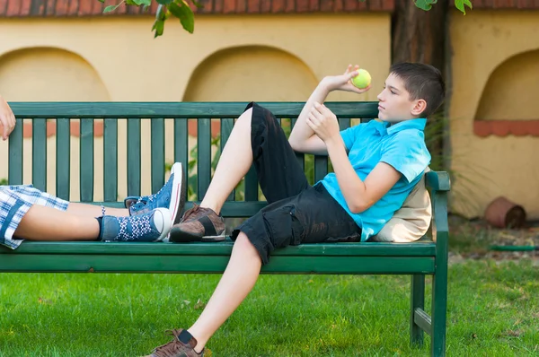 Dos chicos adolescentes lanzando pelota de tenis al aire libre en el día de primavera —  Fotos de Stock