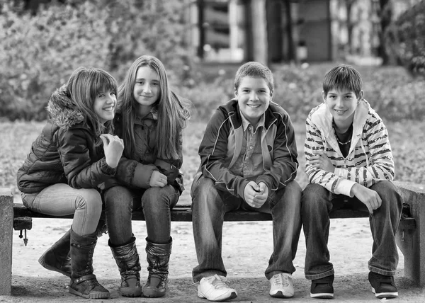 Meninos e meninas adolescentes felizes sentados e se divertindo na primavera — Fotografia de Stock