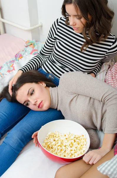 Teenager-Mädchen tröstet ihre traurige Freundin, die auf dem Bett liegt — Stockfoto