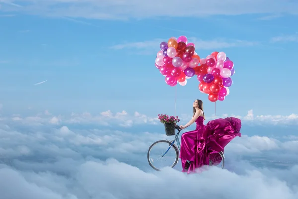 Mujer en hermoso vestido volando en su bicicleta — Foto de Stock