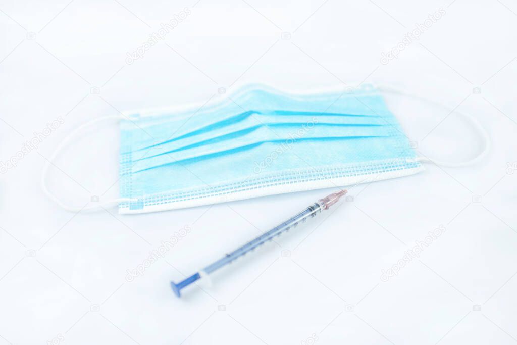 Medical masks and syringes are isolated on a white background