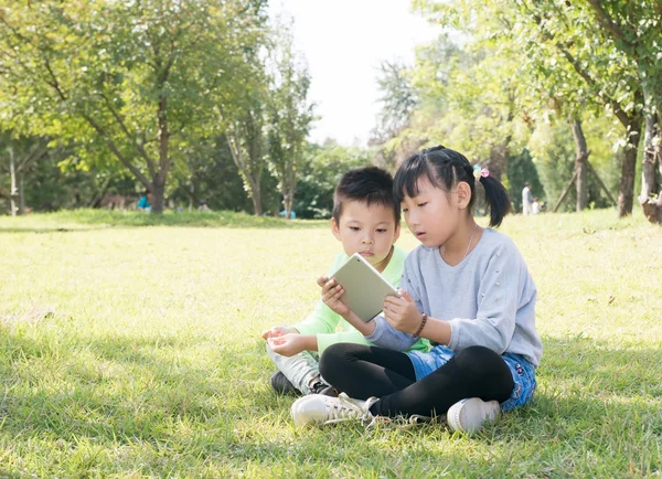 Girl and a boy in the grass — Stock Photo, Image