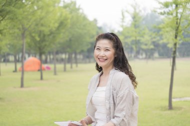 bir tablet tutan yaşlı kadın