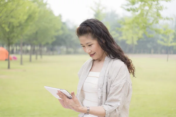 Elderly woman looking Tablet — Stock Photo, Image