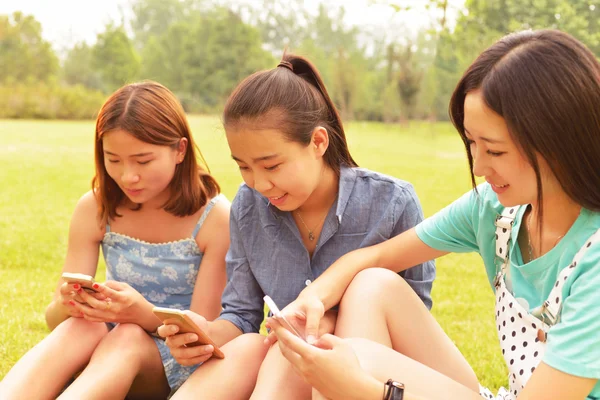 Tre studenter med mobiltelefon — Stockfoto