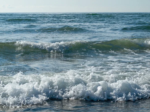 Ondas oceânicas quebrando na praia em um dia claro — Fotografia de Stock