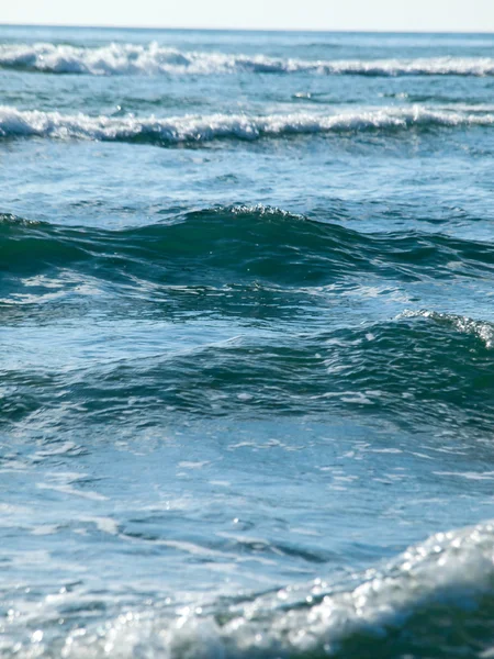 Ondas oceânicas quebrando na praia em um dia claro — Fotografia de Stock