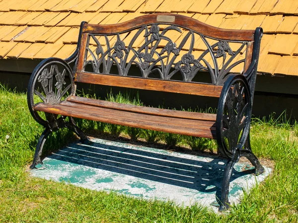 金属和木头公园的长椅上，在阳光明媚的一天 — 图库照片