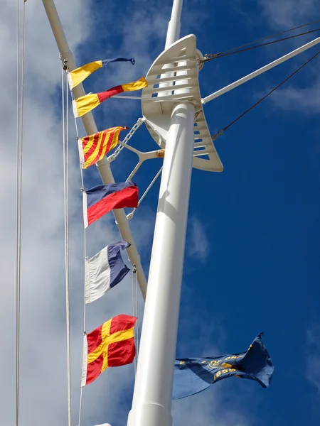 Nautische Flaggen hängen mit Funkwolken am Mast eines Schiffes — Stockfoto